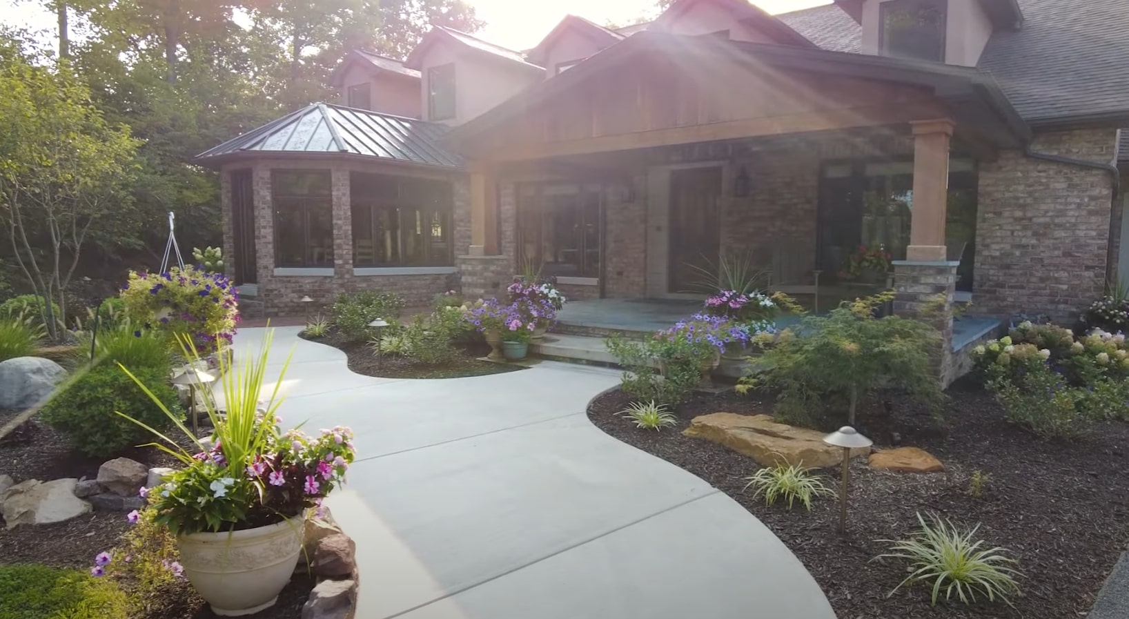 Professional Landscaping Services - Custom Design and Installation Beautiful landscaped home entrance with stone pathways, colorful flower beds, and professional hardscaping in Goodyear, Arizona